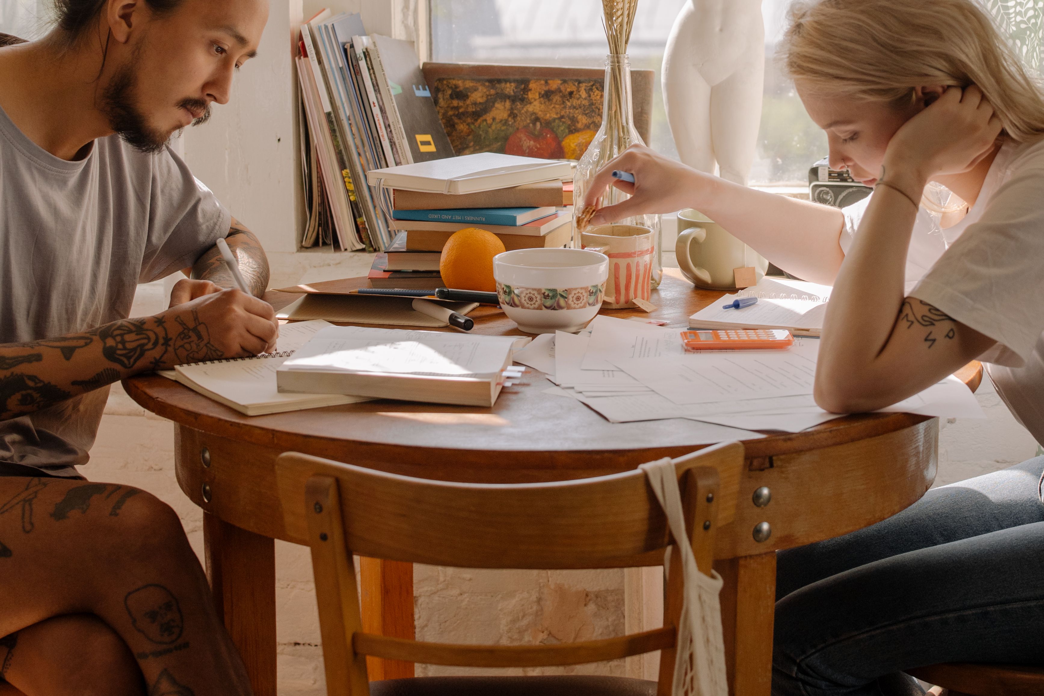 Two people sitting together at a table working through documents